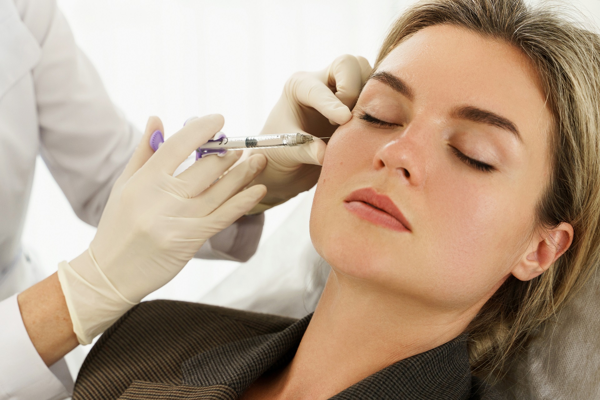 Female client during facial filler injections in aesthetic medical clinic in New York, NY | Re:forma